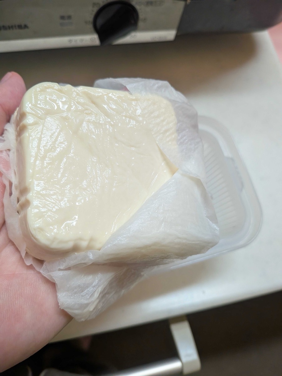 Tofu being removed from packaging wrapped in paper towel