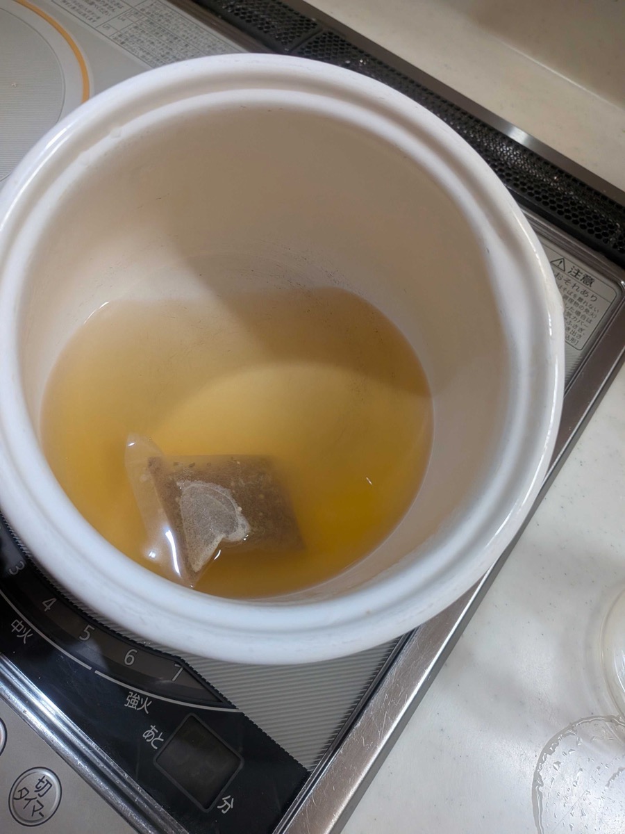 Finished golden dashi broth in a white pot after steeping