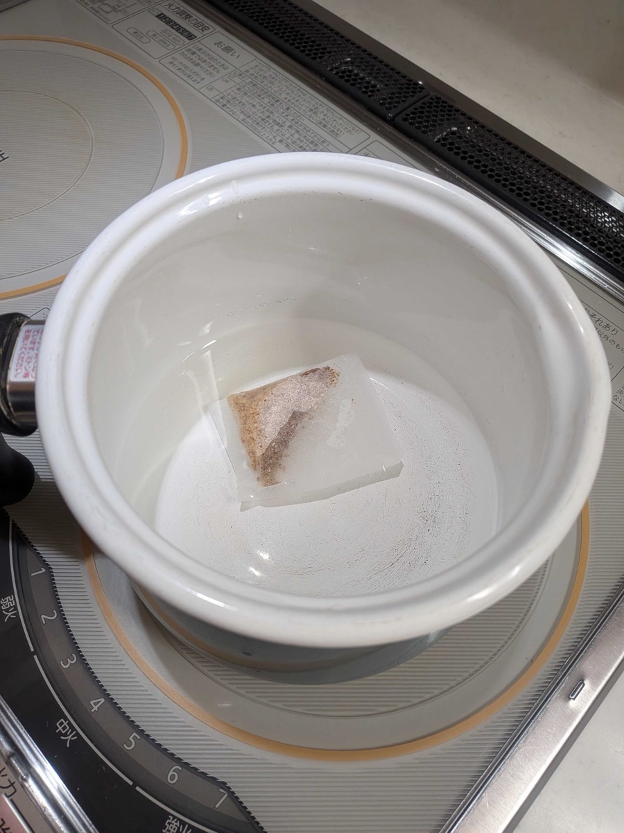 Dashi packet steeping in a white pot on the stove