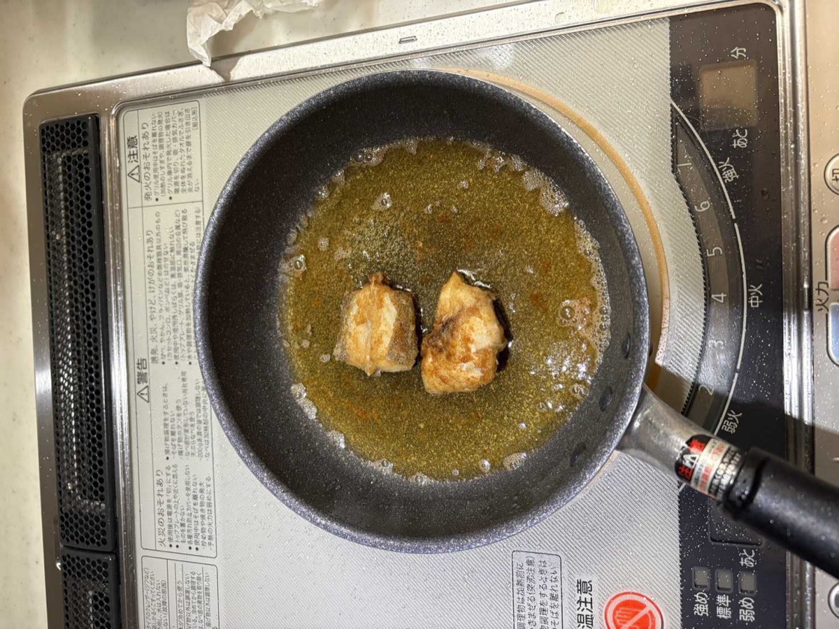 Kochi fish pieces frying in oil in a pan on the stove