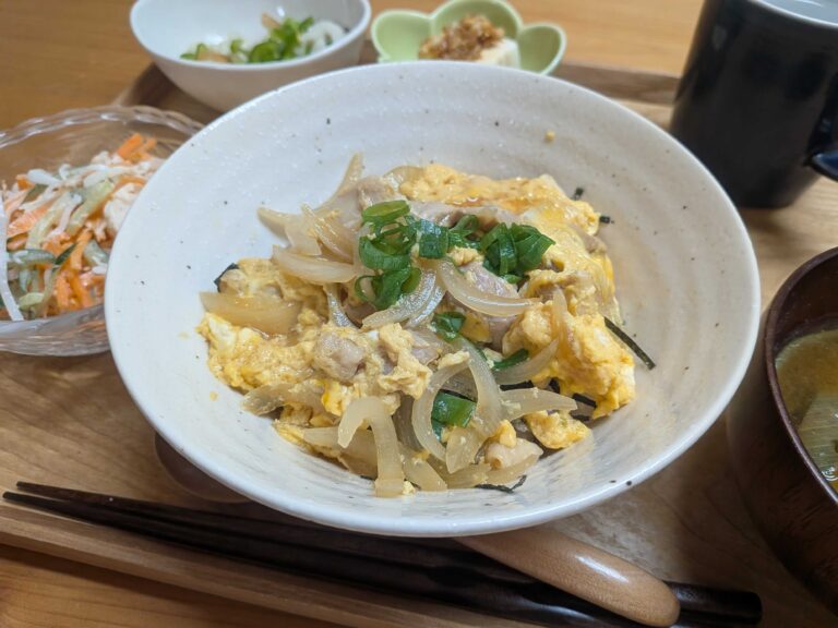 Oyakodon chicken and egg rice bowl topped with green onion and shredded nori