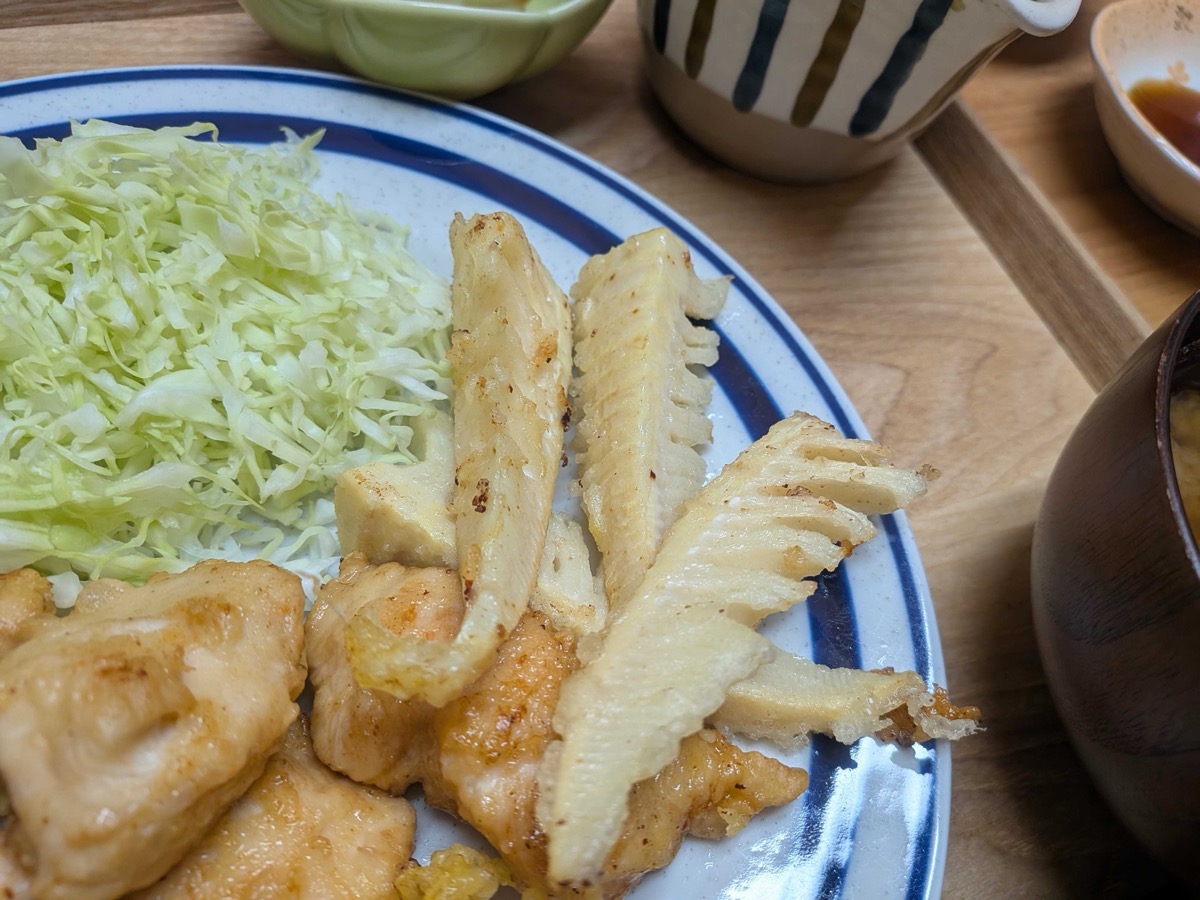 Takenoko tempura served on a plate with shredded cabbage and tori ten