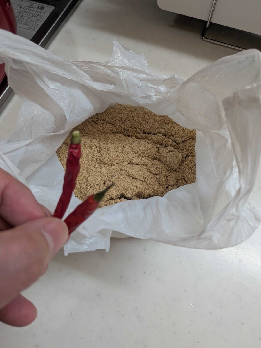 Rice bran in a bag with dried red chilli peppers for boiling bamboo shoots