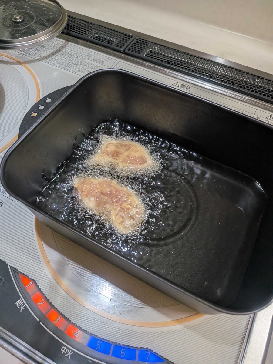 Tori ten chicken frying in hot oil in a deep pan