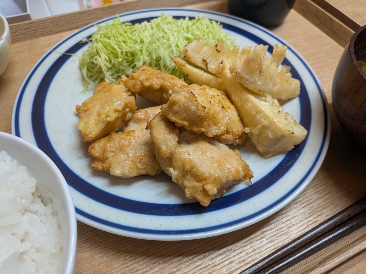 Tori ten served on a plate with shredded cabbage and a bowl of rice