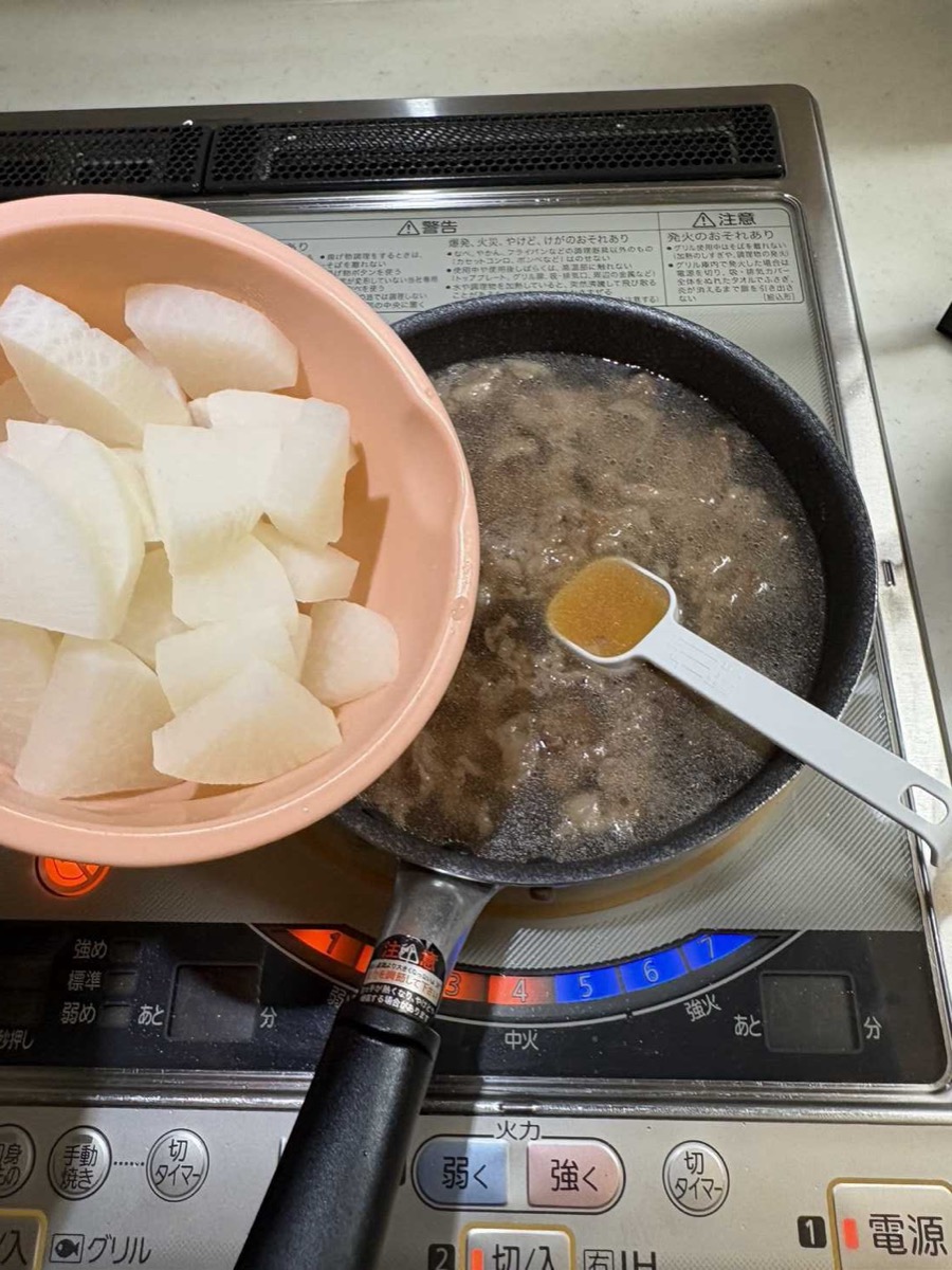 Blanched daikon pieces in a bowl ready to be added to the pan of sautéed beef with dashi broth