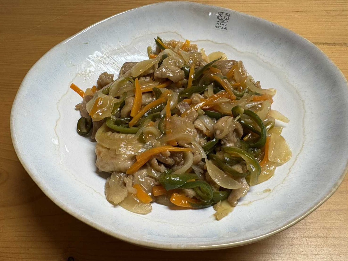 Japanese pork and vegetable sweet-and-sour stir-fry — buta amazu itame — served on a rustic blue-rimmed Portuguese ceramic plate, glossy with sauce and full of julienned carrot, onion, and green pepper