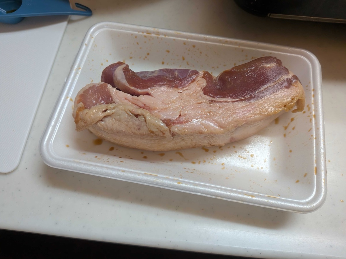 A whole raw pork belly block on a styrofoam tray, ready to be rubbed with soy sauce for Japanese kakuni