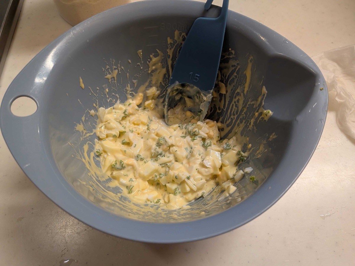 Finished Japanese tartar sauce in a grey mixing bowl — creamy with visible flecks of egg, onion, and parsley