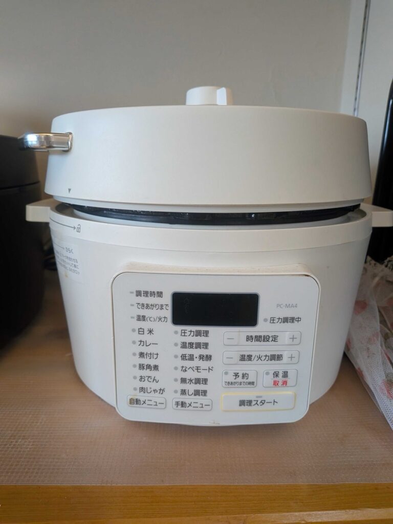 An Iris Ohyama PC-MA4 electric pressure cooker on a wooden counter — one of the most-used modern Japanese kitchen tools, with presets for nikujaga, Japanese curry, and kakuni