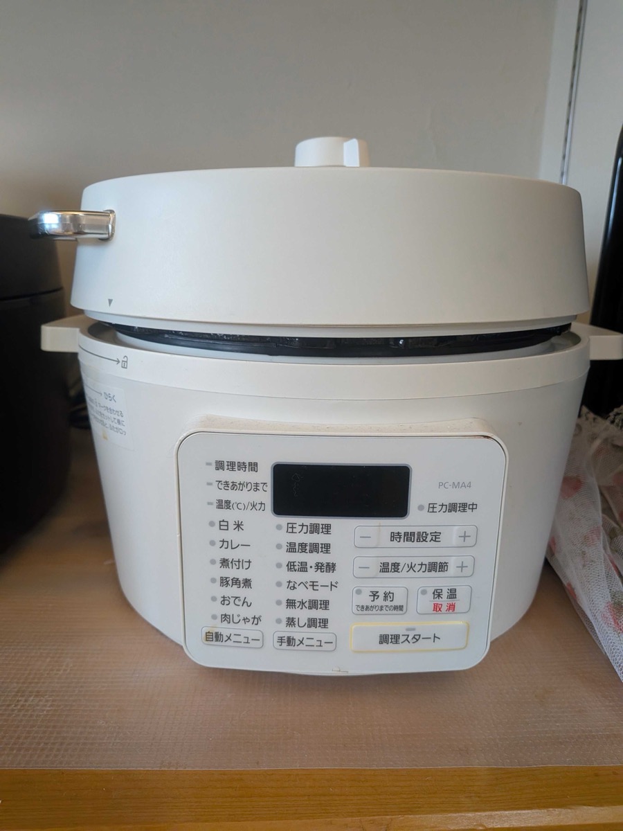 An Iris Ohyama PC-MA4 electric pressure cooker on a wooden counter — one of the most-used modern Japanese kitchen tools, with presets for nikujaga, Japanese curry, and kakuni