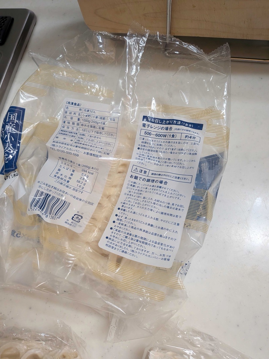 The back of a frozen Sanuki udon package showing microwave instructions — 4 minutes at 500–600W per portion