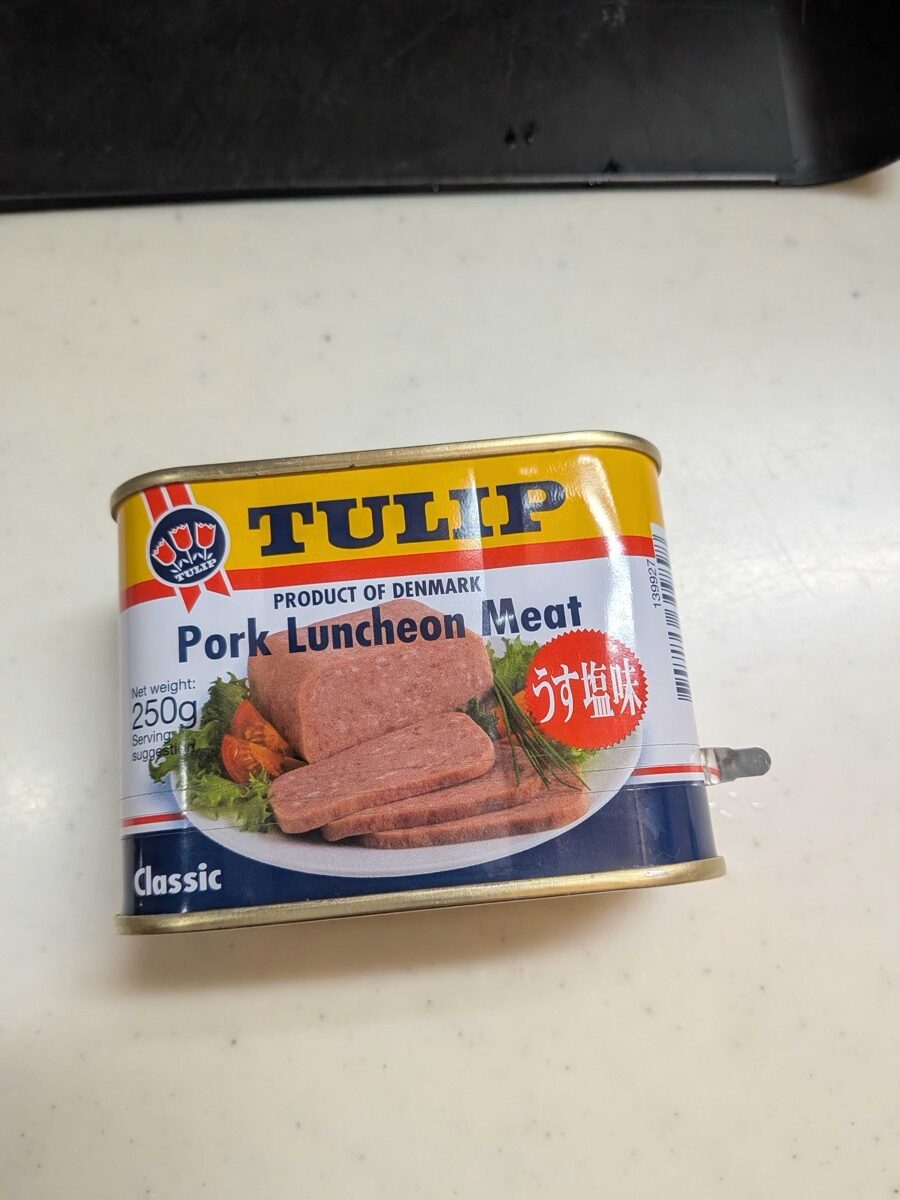 A can of TULIP Pork Luncheon Meat (Danish brand, low-salt version) on a kitchen counter — the spam-style meat used for Japanese spam onigiri