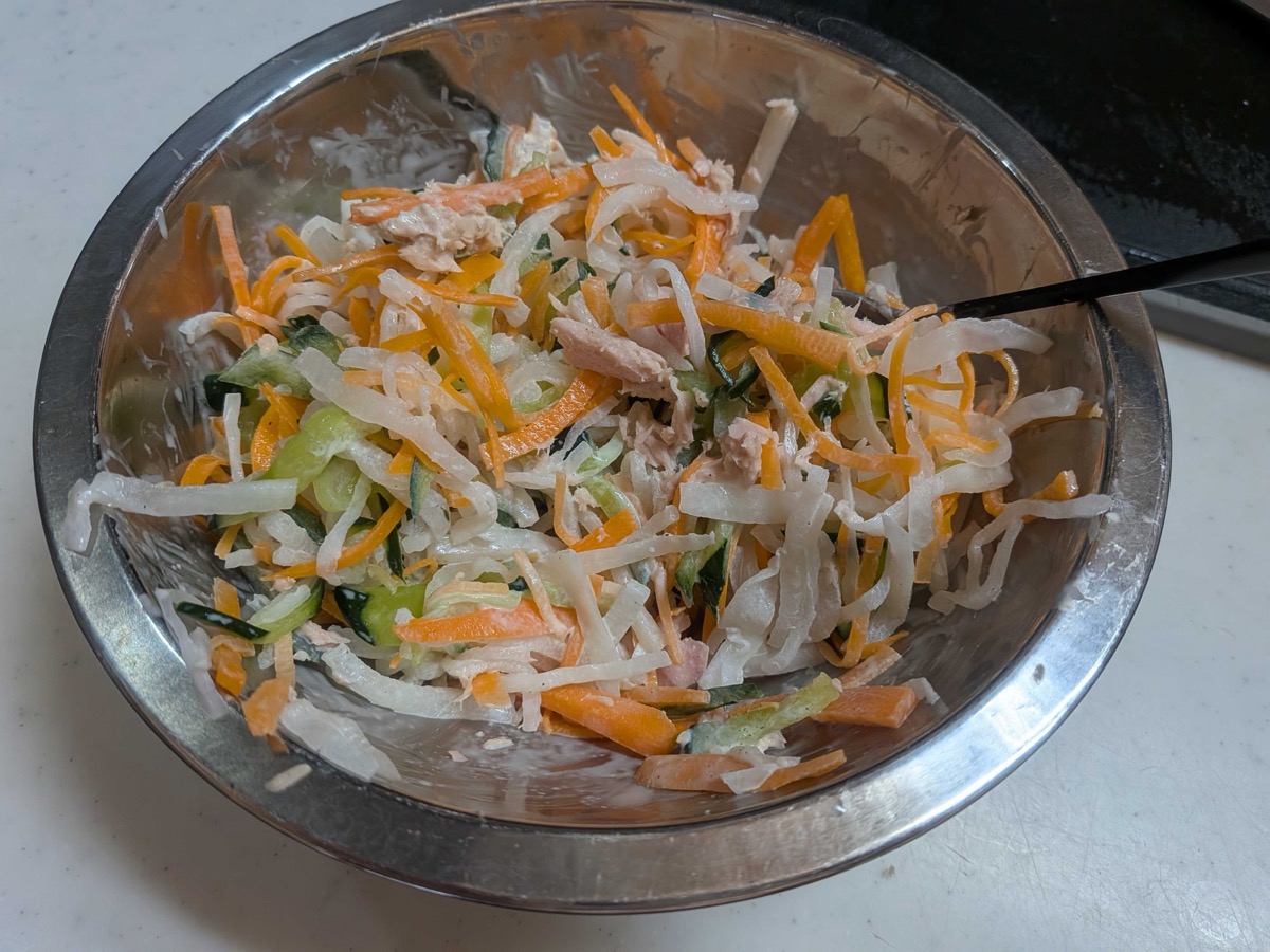 The daikon salad tossed together with tuna and mayonnaise in a metal bowl