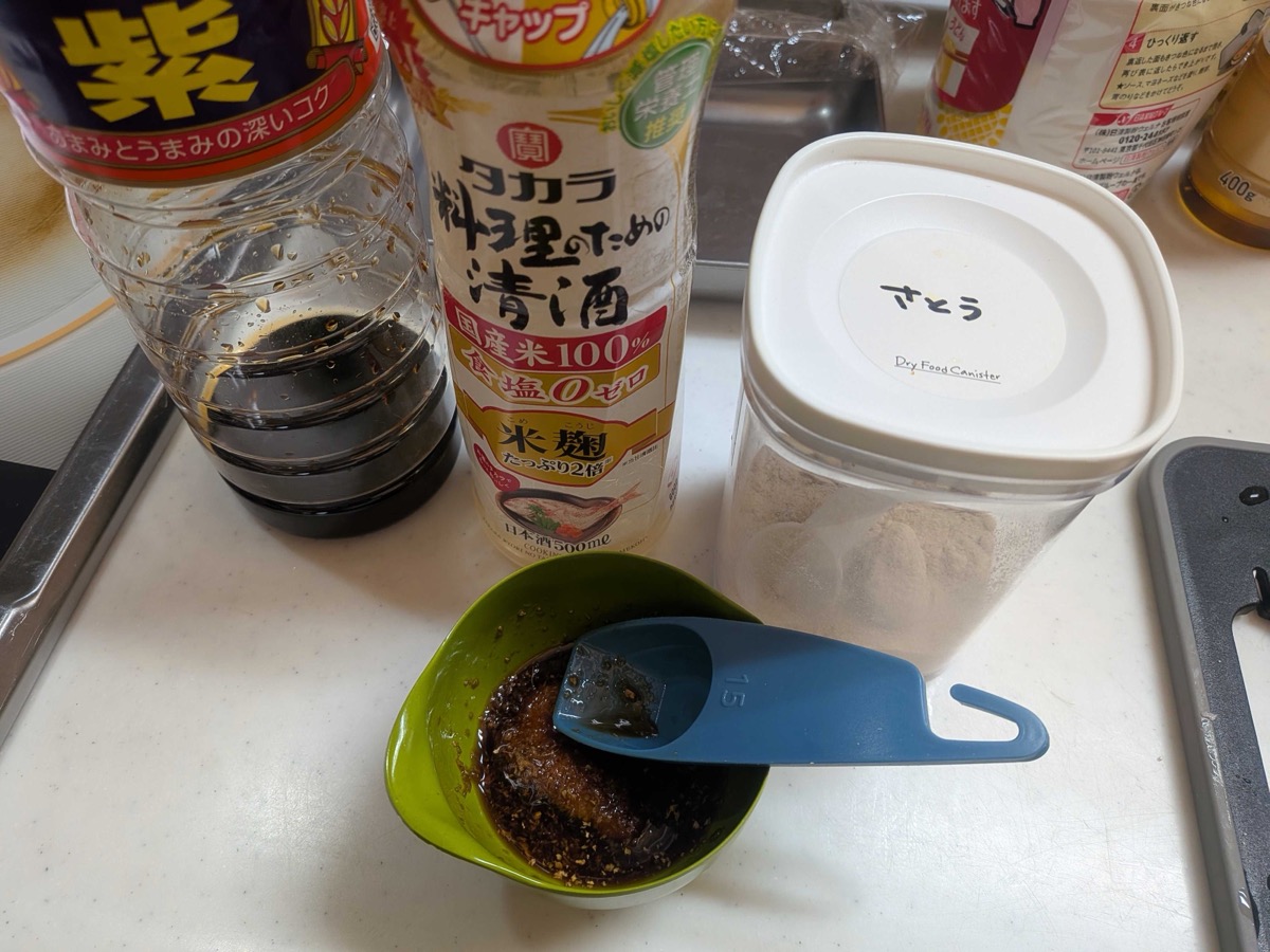 Ginger sauce mixed in a bowl with soy sauce, cooking sake, and sugar in the background