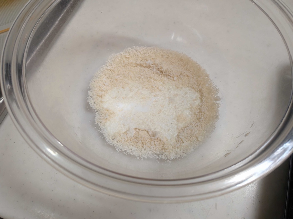 Panko breadcrumbs soaking in milk in a glass bowl