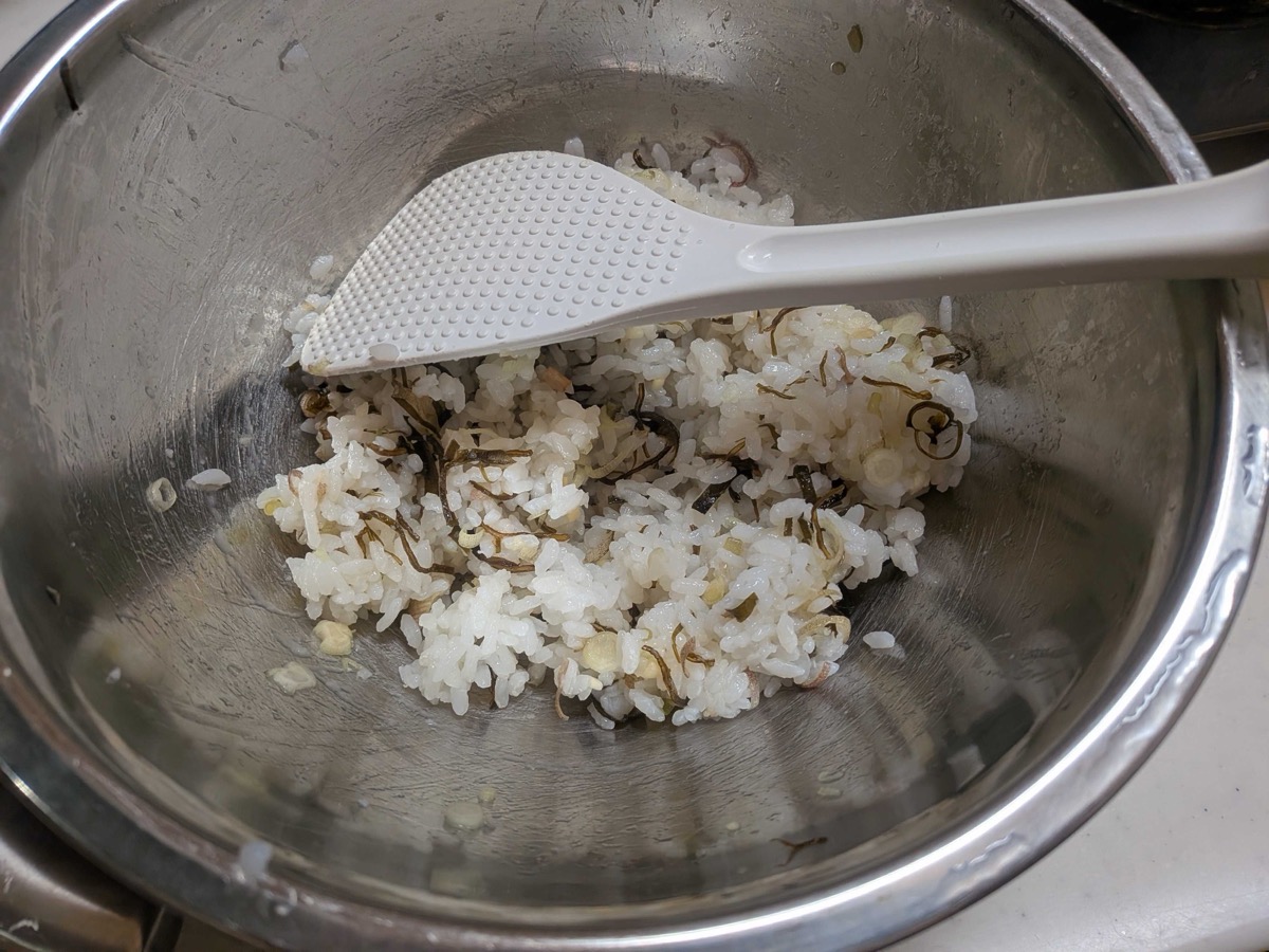 The rice mixed with myoga and shio kombu using a rice paddle