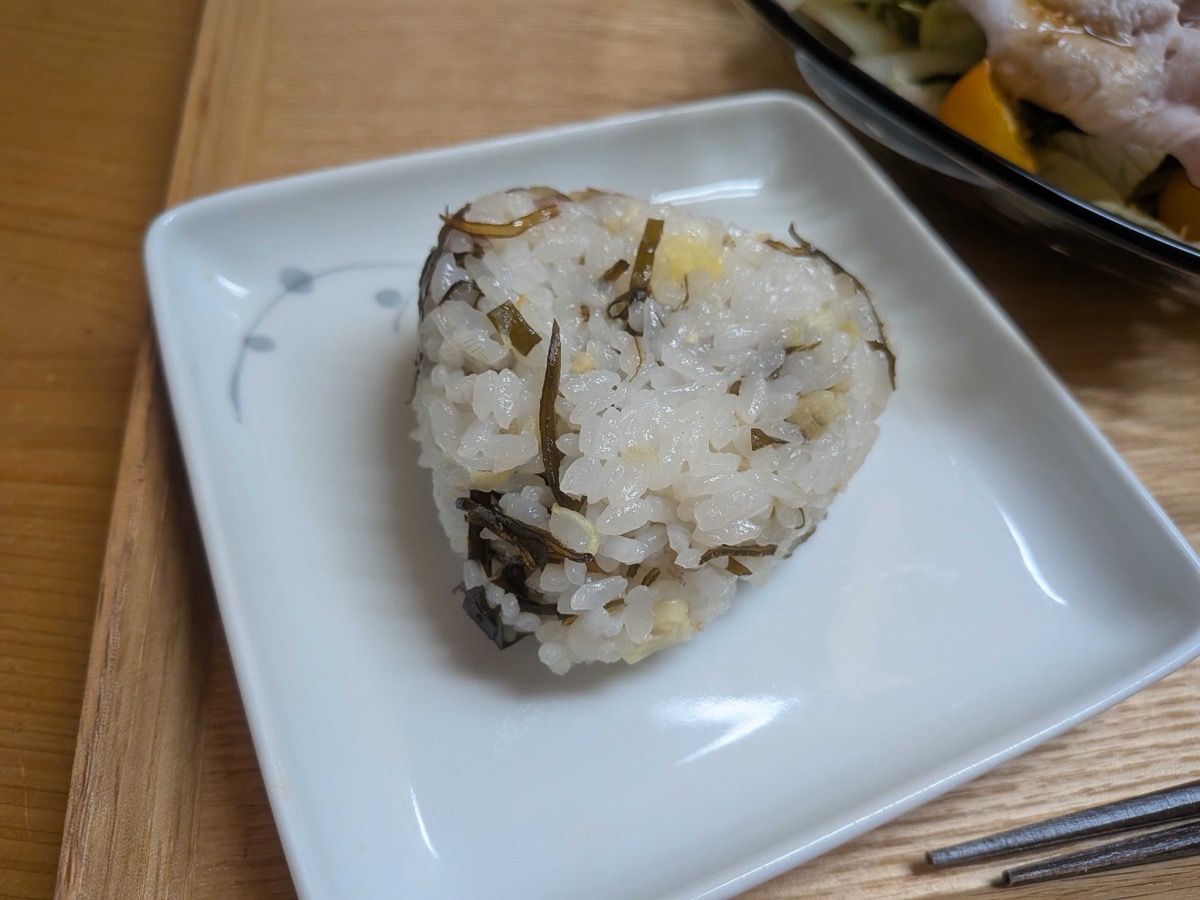 A single shaped myoga and shio kombu onigiri on a small plate