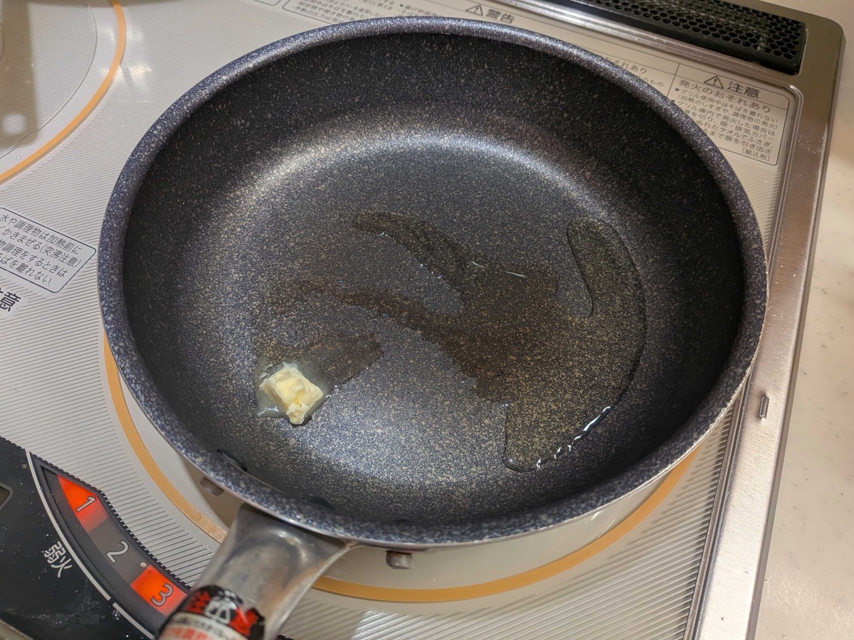 A pat of butter melting in a non-stick frying pan
