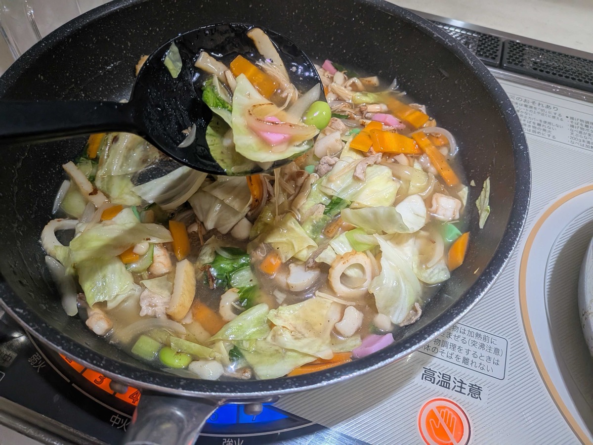 The finished thick ankake gravy full of vegetables and seafood in the pan