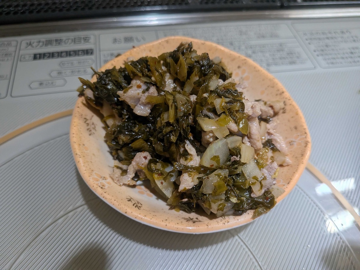 The cooked takana, pork, and onion mixture set aside in a small floral dish