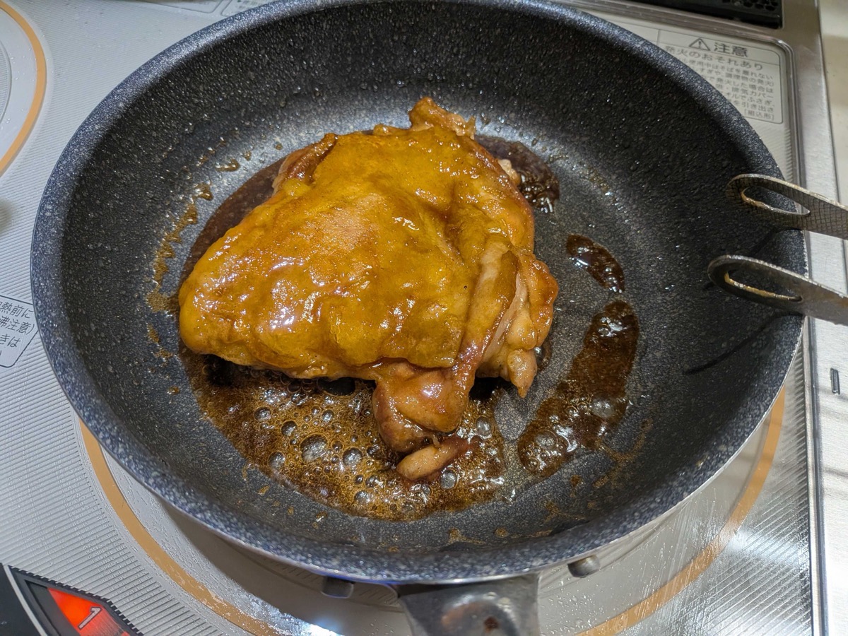 Fully glazed glossy teriyaki chicken thigh in the pan
