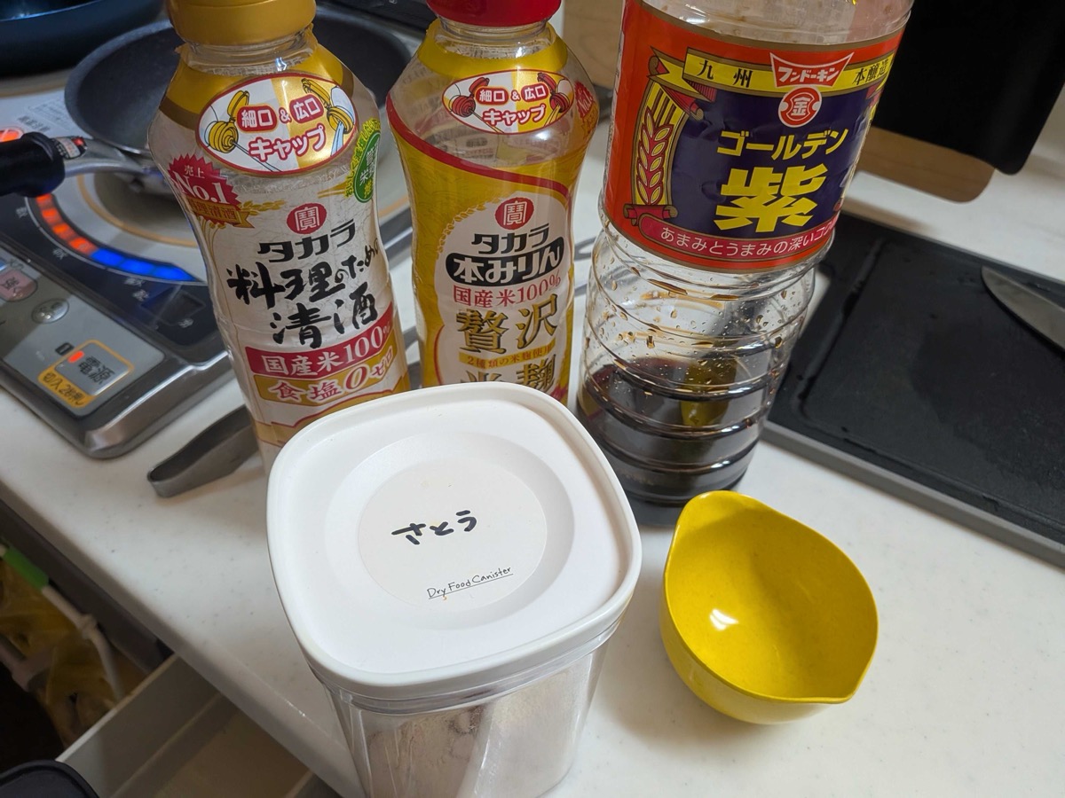 Teriyaki sauce ingredients — Takara cooking sake, mirin, Golden soy sauce, and a sugar canister on the counter