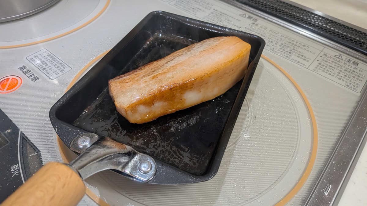 Pork belly block browned on the surface in the pan