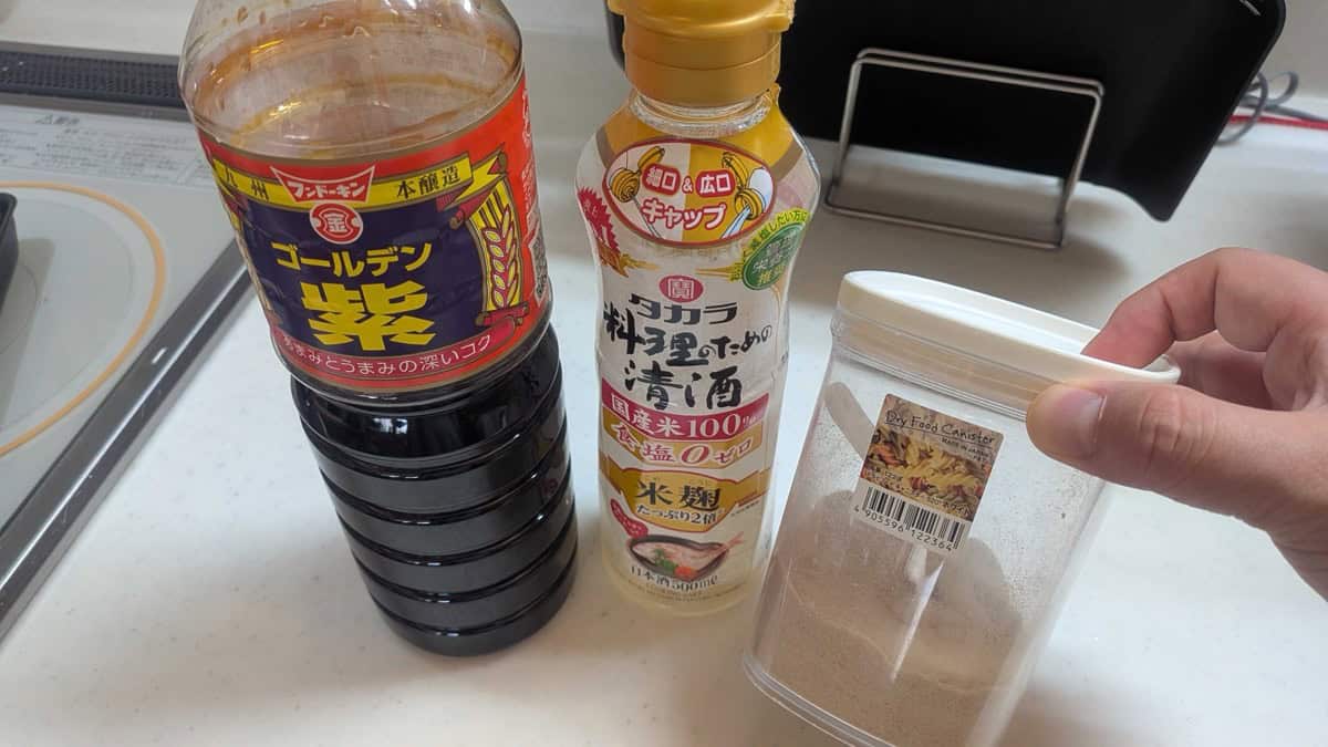 Bottles of Fundokin Golden Murasaki soy sauce, Takara cooking sake, and a canister of sugar on a kitchen counter