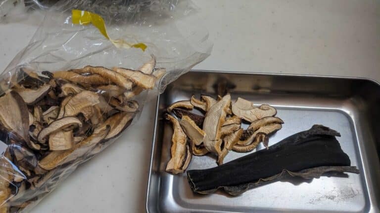 Dried kombu kelp and dried shiitake mushrooms on a metal tray — natural dashi substitute ingredients