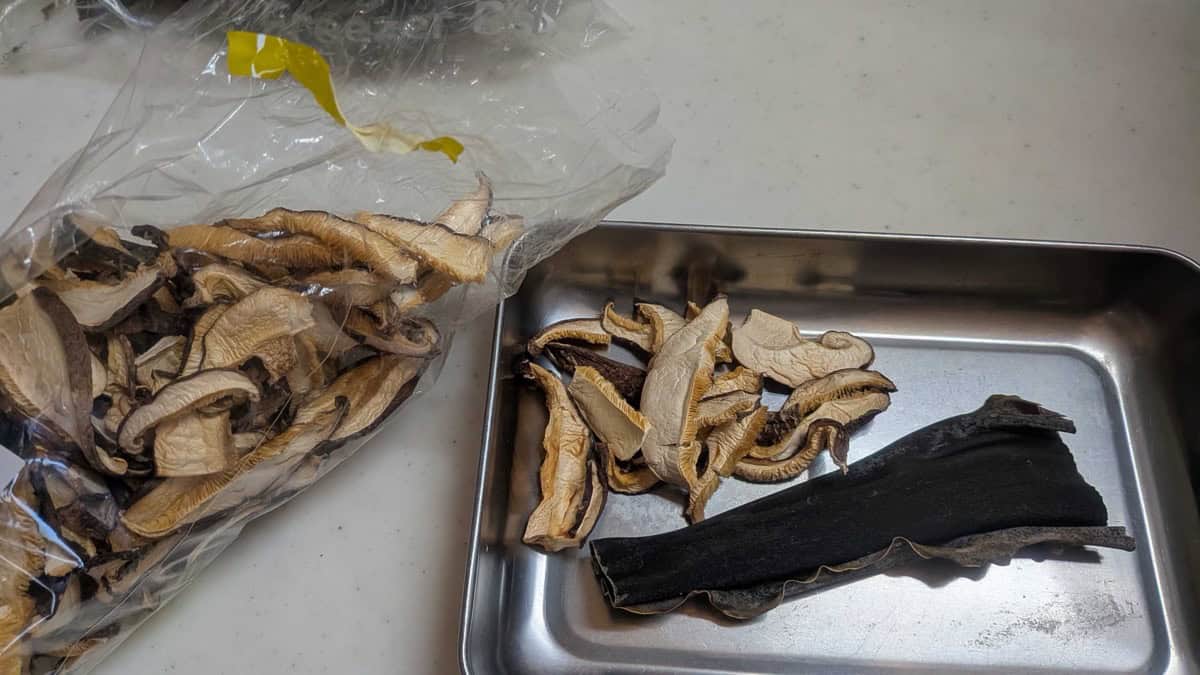 Dried kombu kelp and dried shiitake mushrooms on a metal tray — natural dashi substitute ingredients