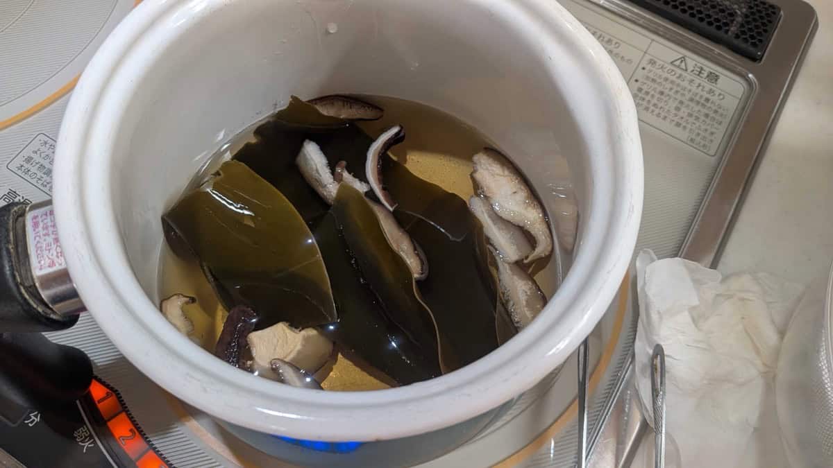 Kombu and a couple of dried shiitake mushrooms steeping in water in a pot