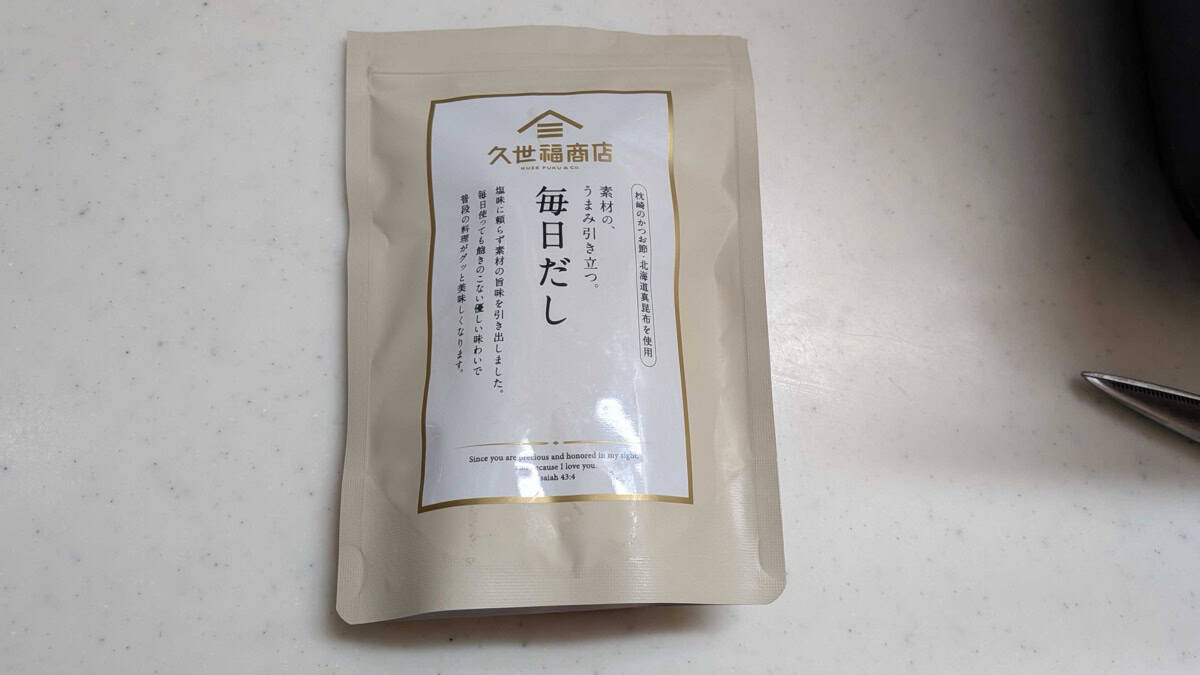 A single Kuze Fuku dashi sachet held next to the resealable pouch it comes in