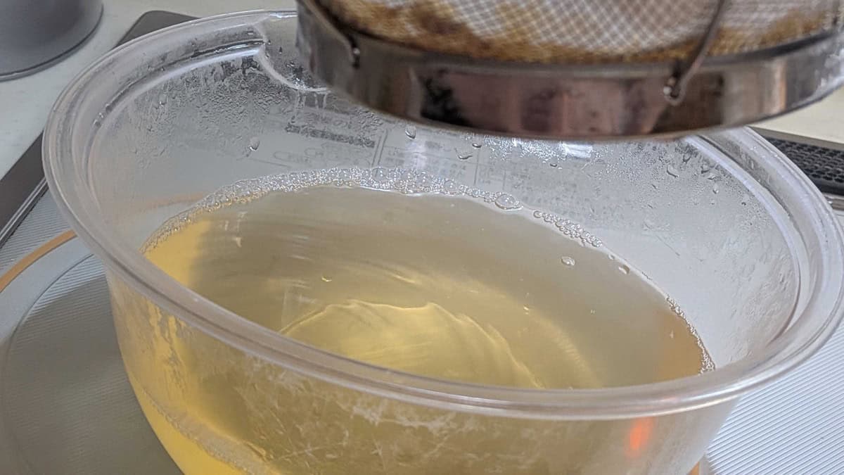 Straining the paler second dashi (niban dashi) into a container
