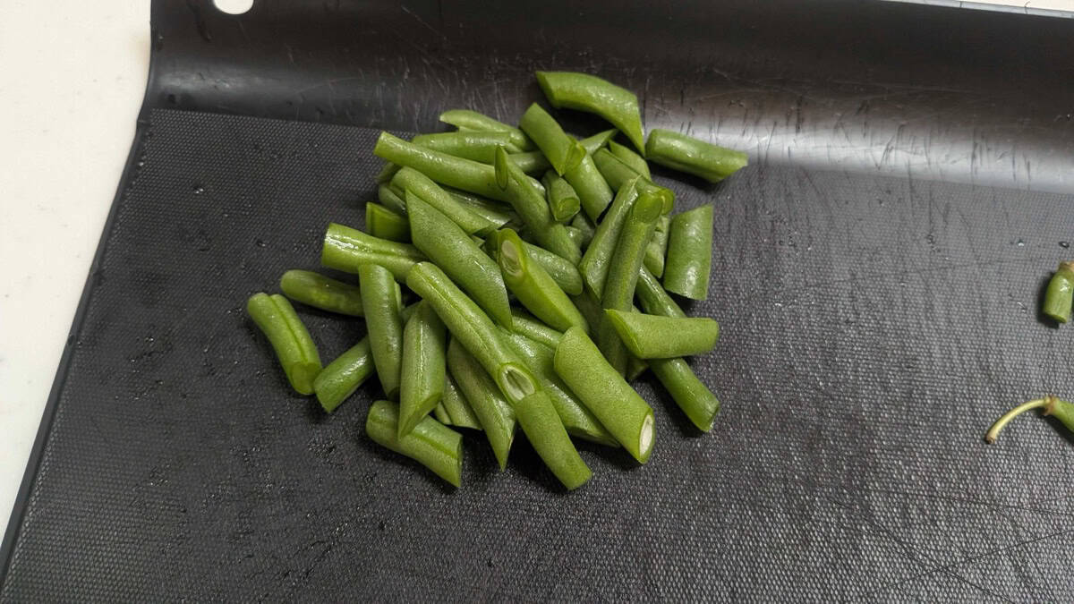 Green beans cut into bite-size pieces, piled on a cutting board