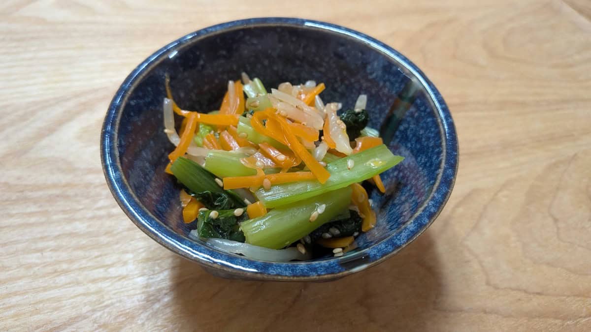 Three-color namul served in a blue bowl — komatsuna, carrot, and bean sprouts with sesame