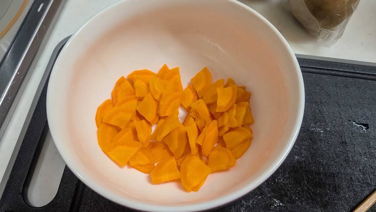 Thinly sliced carrot in a white bowl