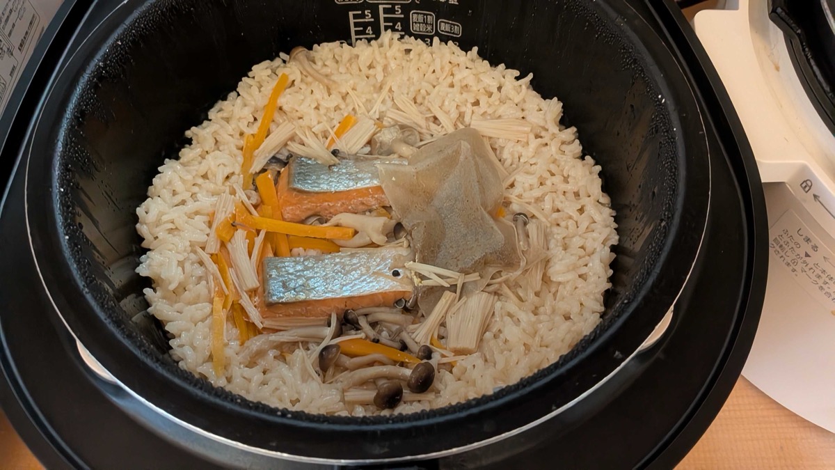 The just-cooked salmon takikomi gohan with the fillets and dashi packet on top of the rice