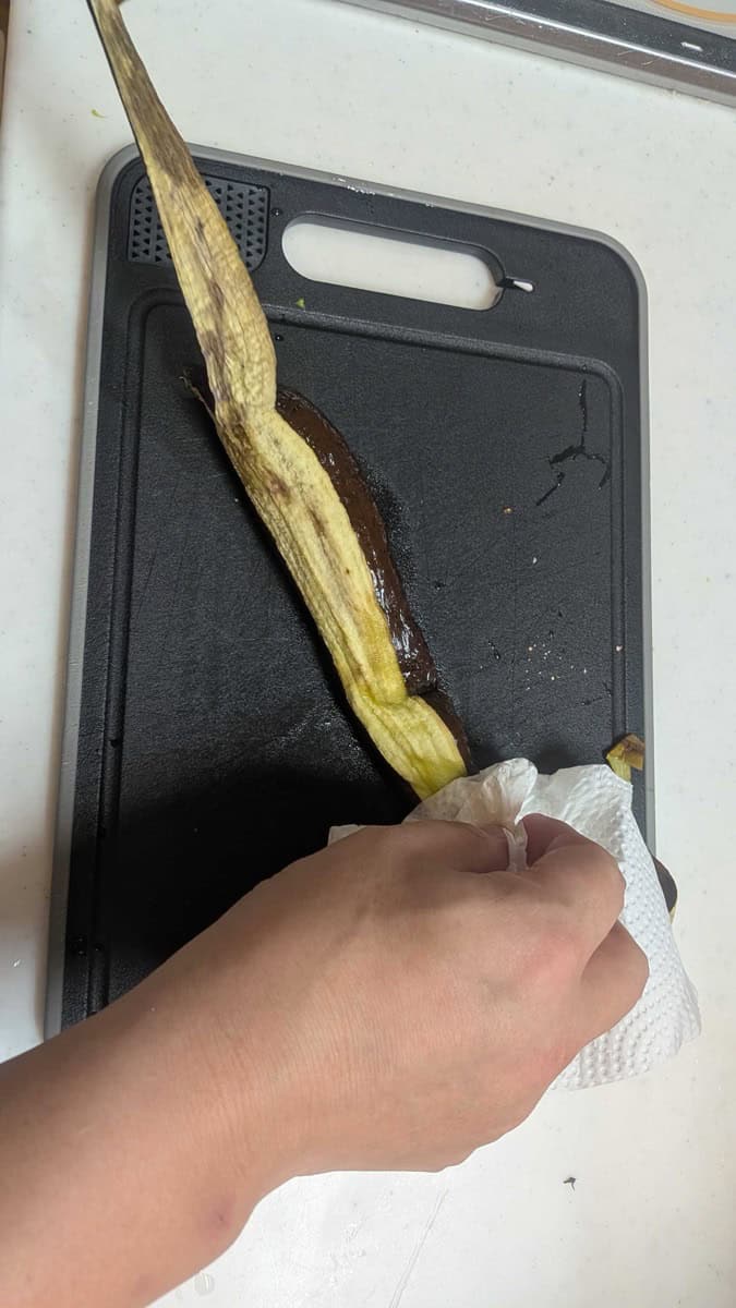 Grilled eggplant with the skin pulled away in strips, showing the soft pale flesh underneath