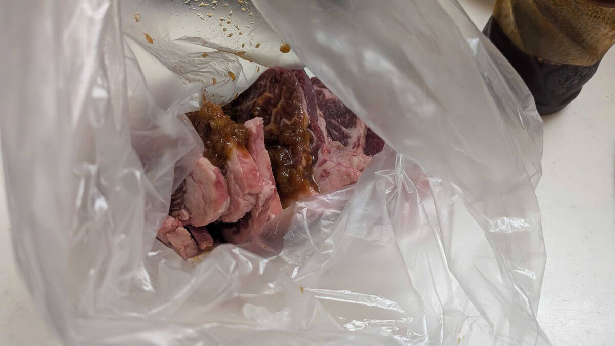 Sliced beef in a plastic bag with yakiniku sauce and grated onion poured over it