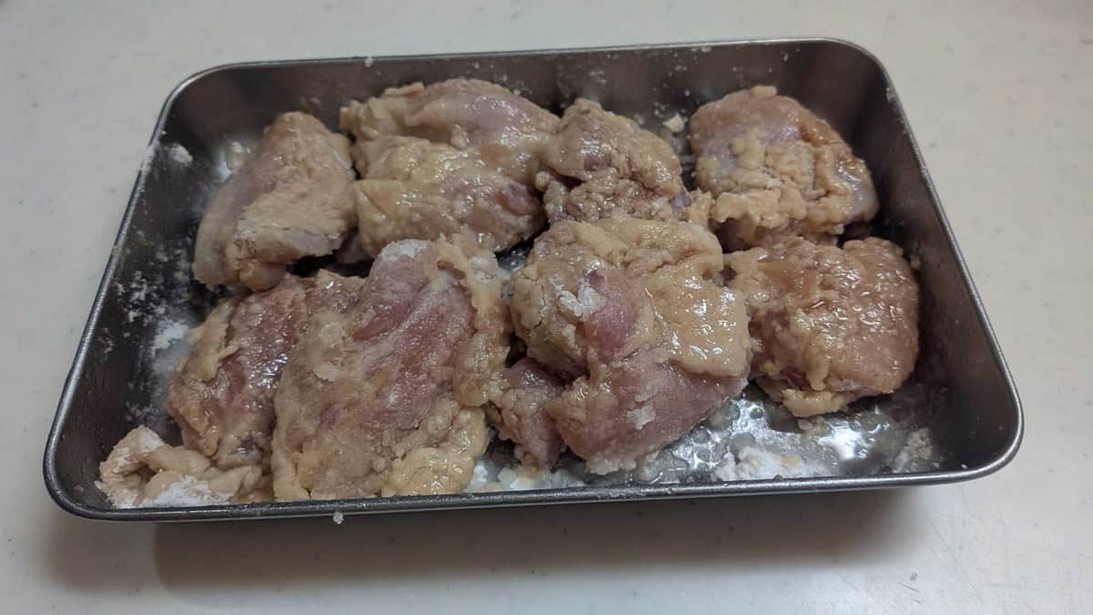 Chicken pieces after spraying with rice oil, the potato starch coating damp all over with no dry white powder left