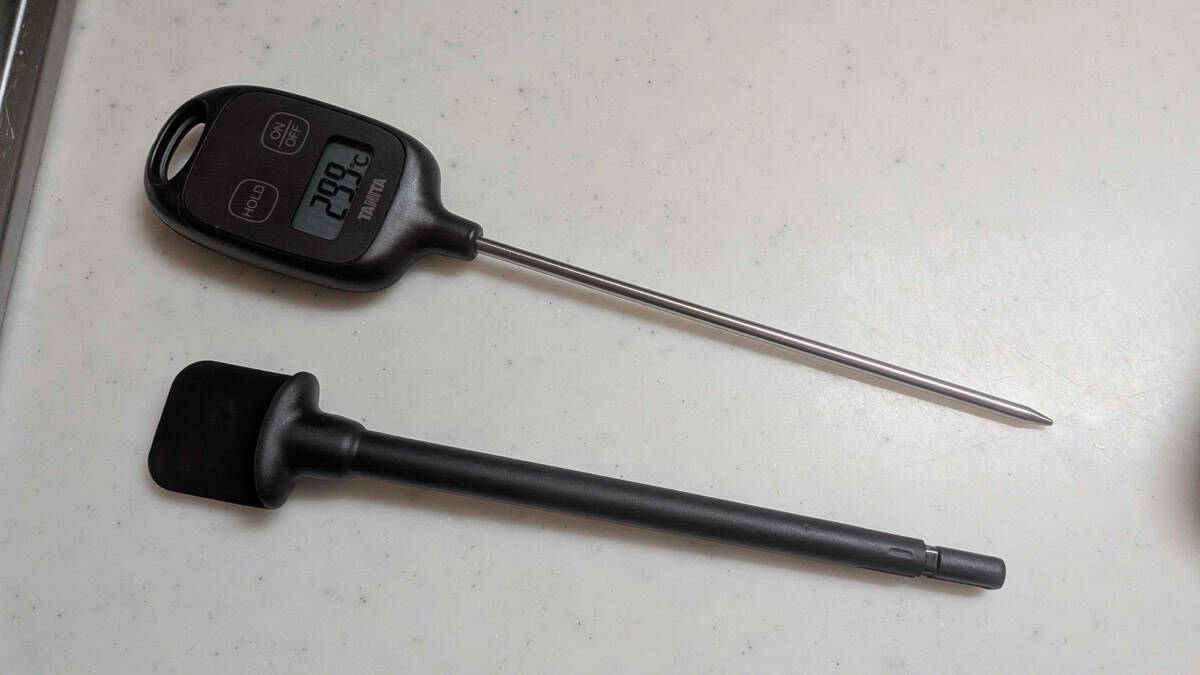 The Tanita digital probe thermometer used to check the chashu center temperature, next to a silicone spatula on the counter