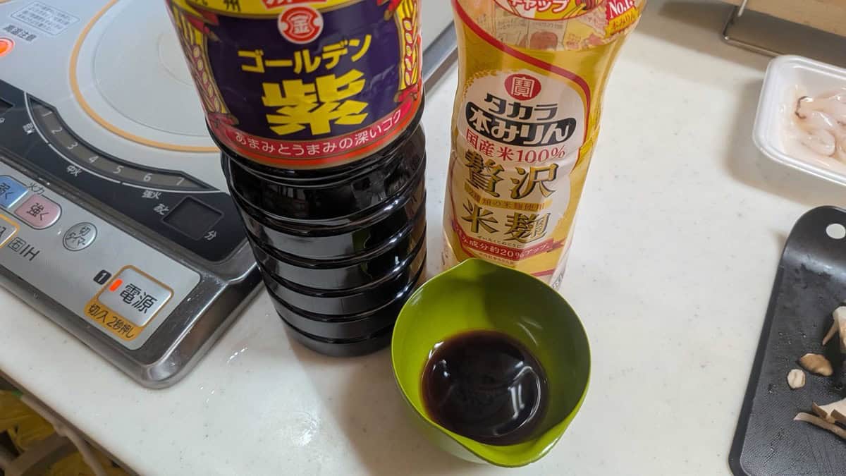 Kyushu soy sauce and hon-mirin bottles next to a small green bowl holding the mixed sauce