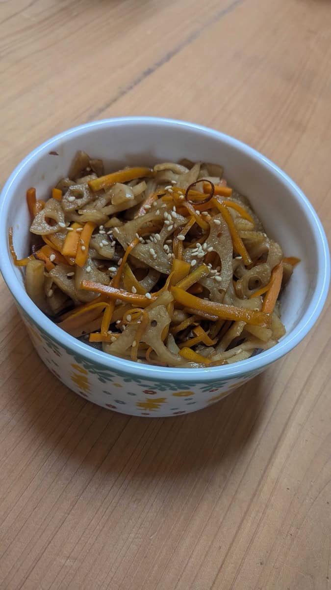 Kinpira renkon — Japanese lotus root side dish with carrot and sesame seeds, served in a small floral bowl