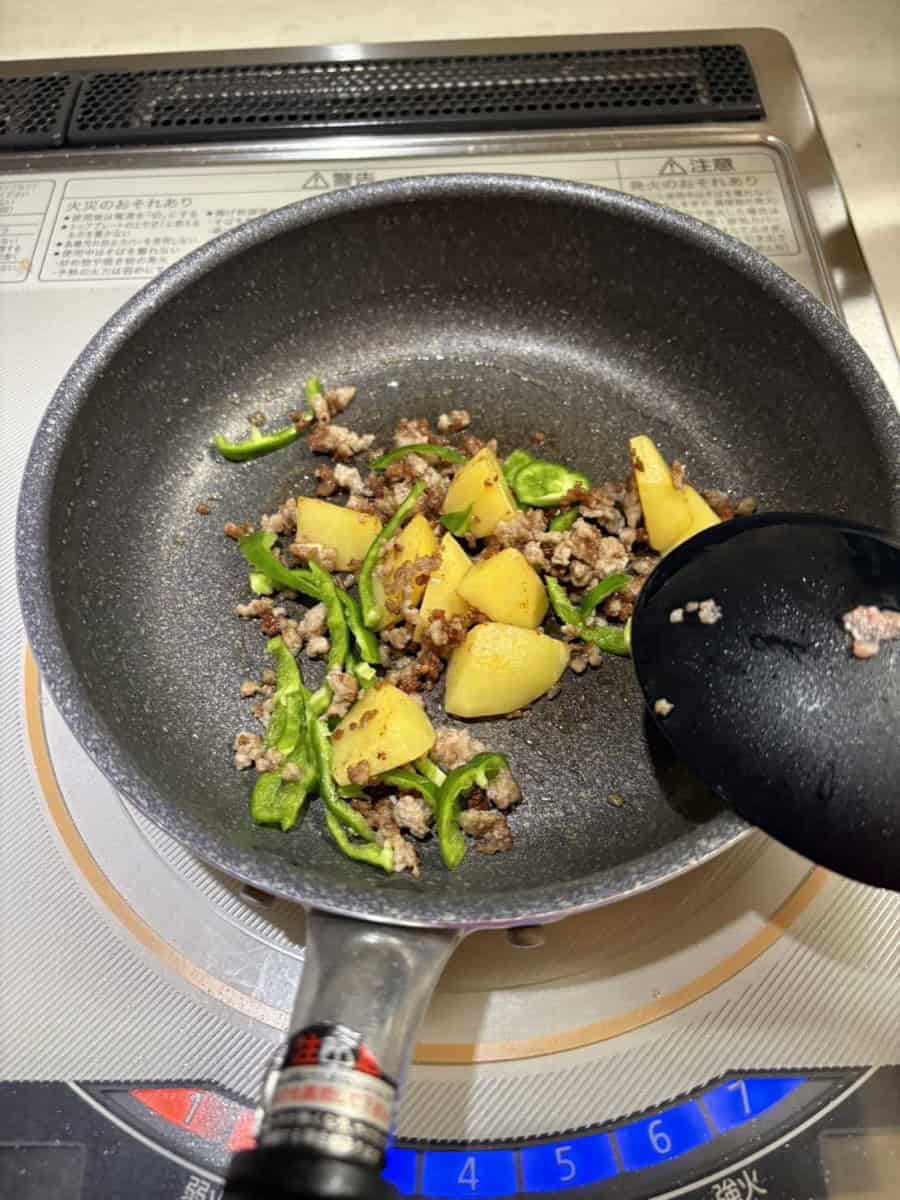 Green pepper strips added to the pan of browned pork and potato