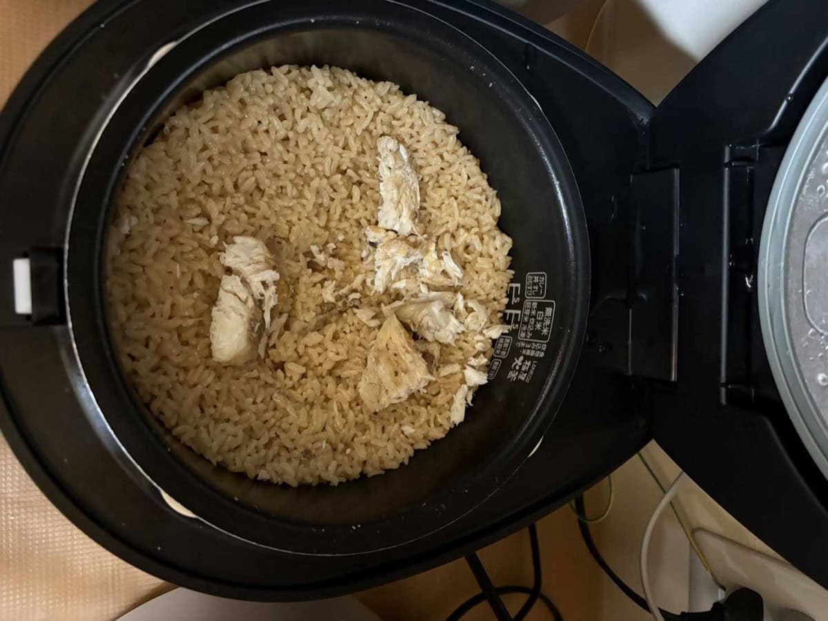 Flaked white sea bream returned to the seasoned rice in the rice cooker pot, before mixing